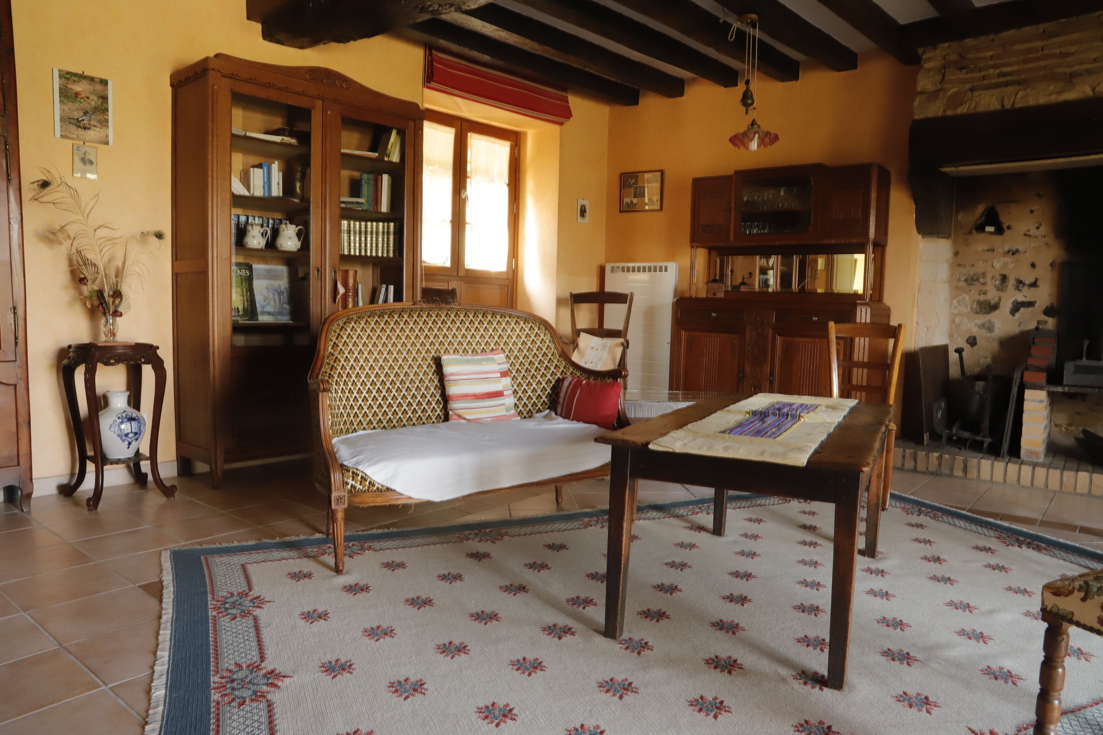 A cozy living room with a sofa, a wooden table, and a bookshelf.