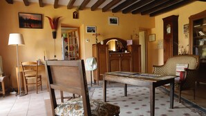 A cozy living room with a wooden table, chairs, a bookshelf, and a lamp. - Country home in the heart of France, 20 minutes away from Sancerre (Assigny)