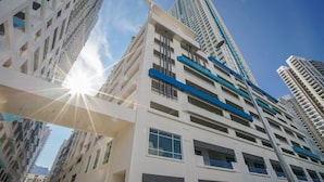 A modern high-rise building with multiple balconies and large windows, surrounded by other tall buildings. - Pool View 3BR* Walk to SHOPS EAT * AC & Wi-Fi (Tanjung Tokong)