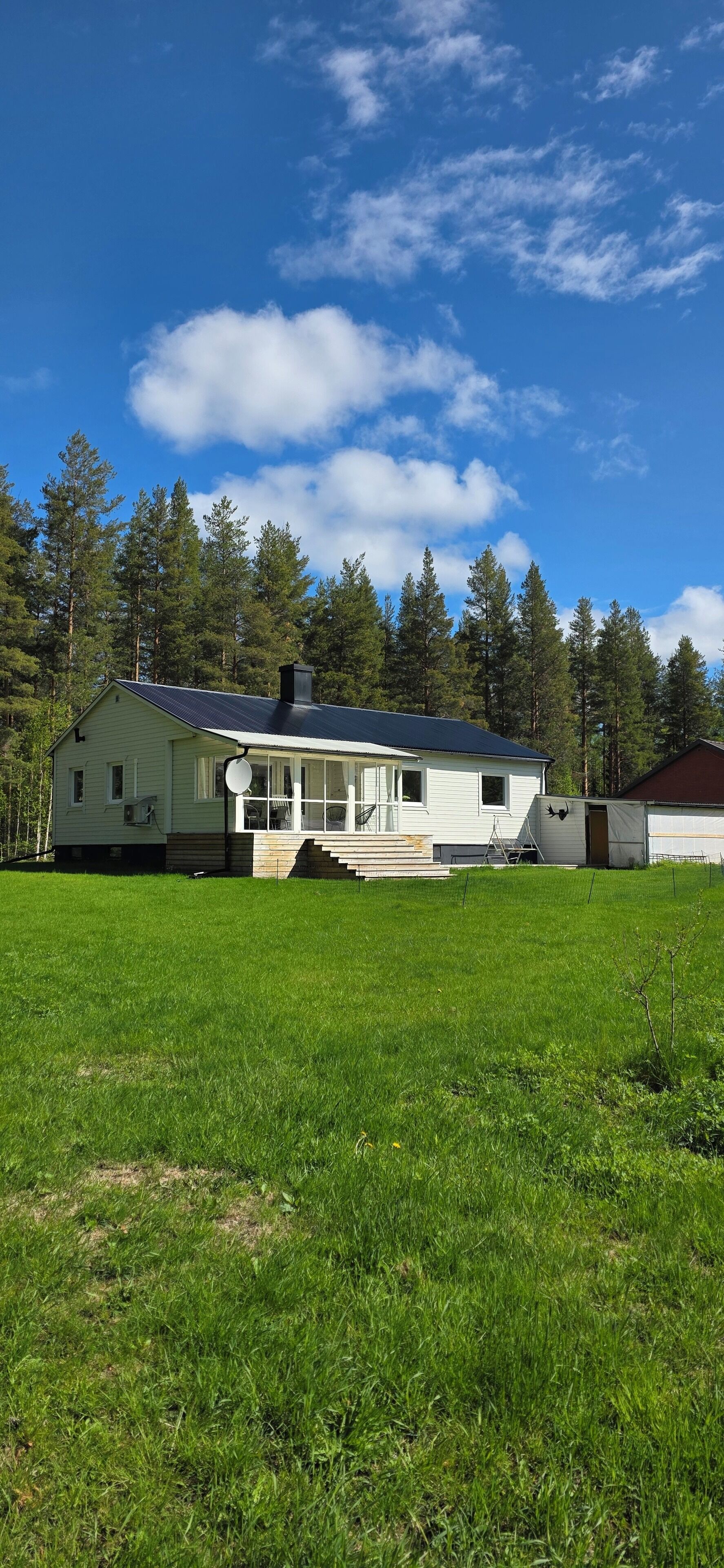 A single-story house with a sloped roof, a chimney, and a satellite dish.