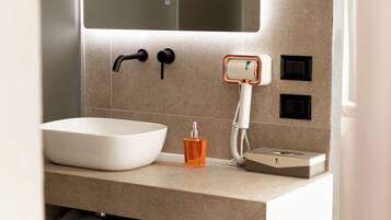 A modern bathroom with a large white sink, a mirror above it, and a towel rack below.