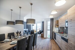 A modern kitchen with wooden cabinets and a built-in oven. - AlpenParks Hotel & Apartment Alpendorf (Sankt Johann im Pongau)