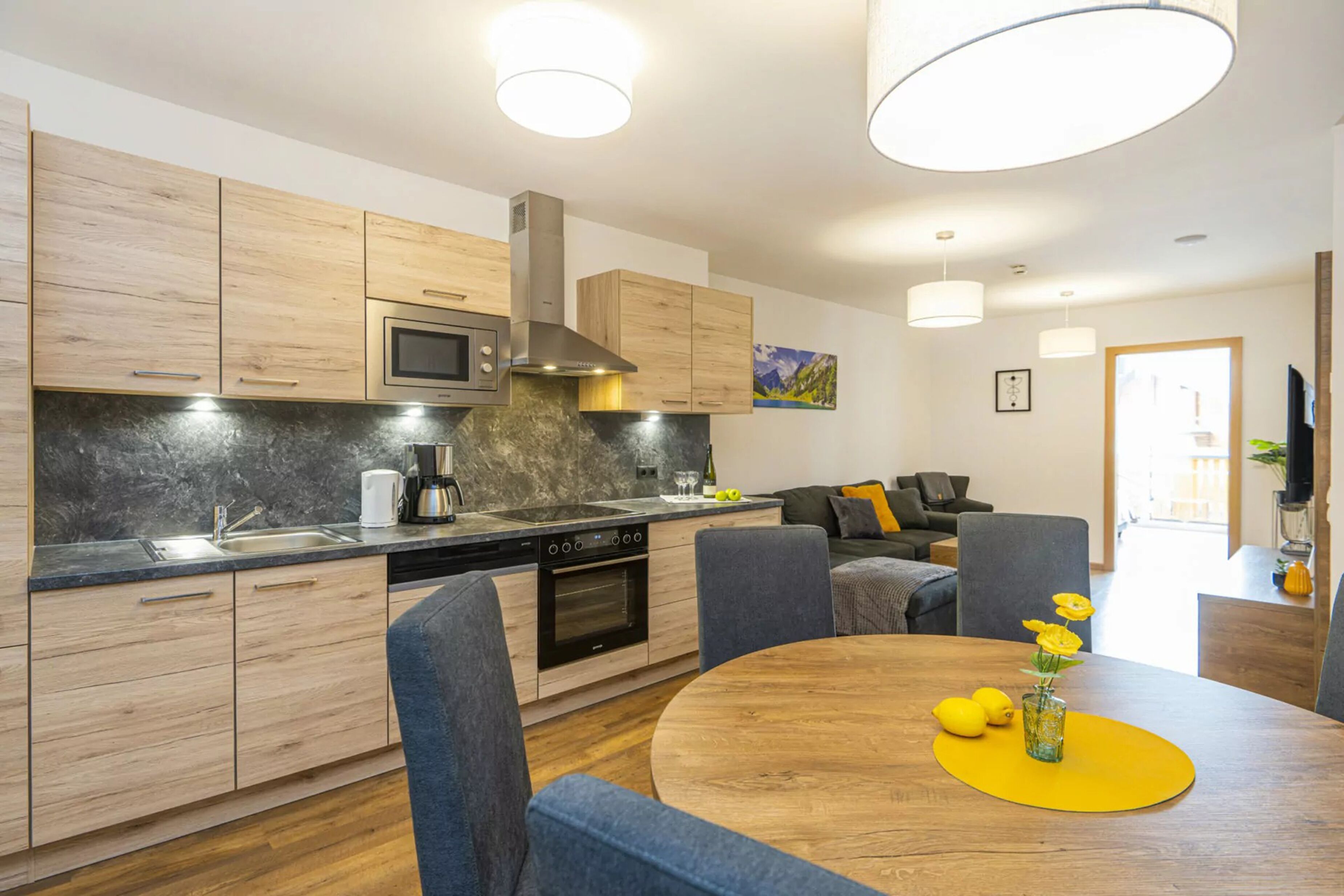 Una cocina moderna con armarios de madera, microondas integrado y estufa.