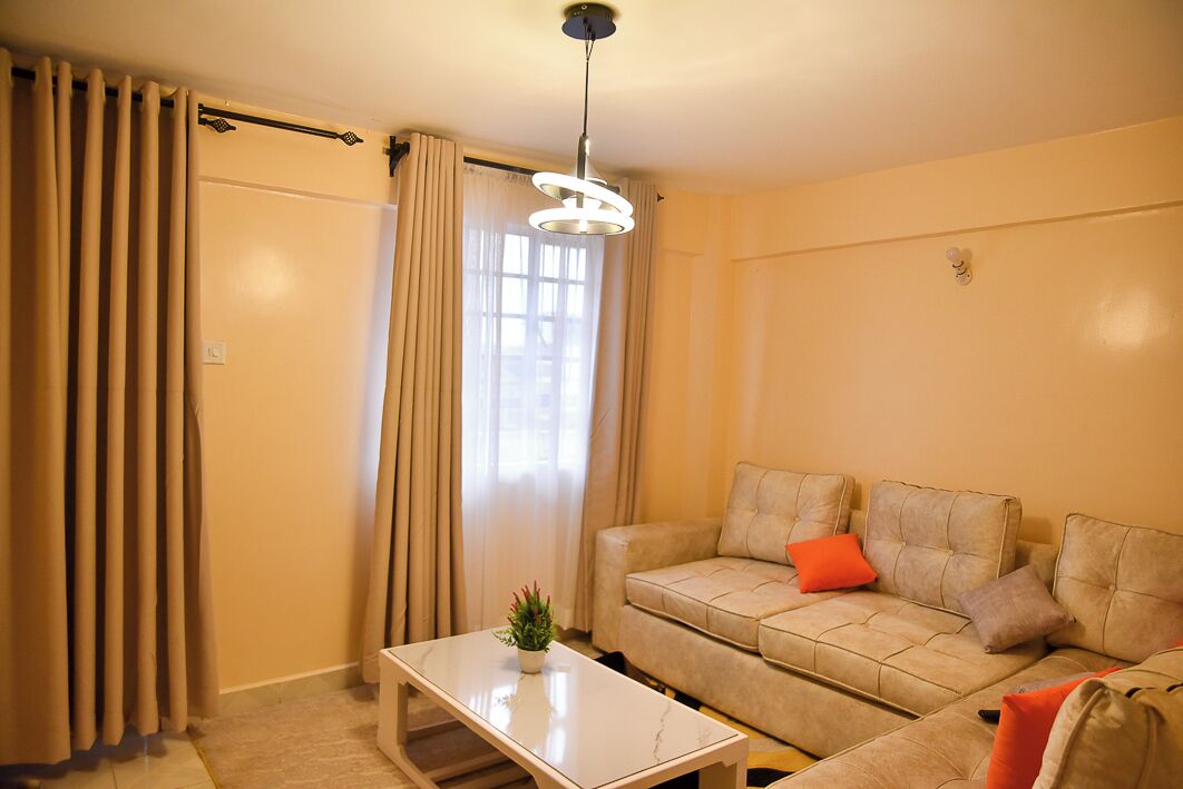 Un salon avec un canapé beige, une table basse et une suspension.