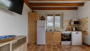 A compact kitchen with wooden cabinets, a white refrigerator, a stove, a microwave, and a sink. - Maison Le Berylune - 16bis Rue de Champ des Varennes - Abrest (Abrest)