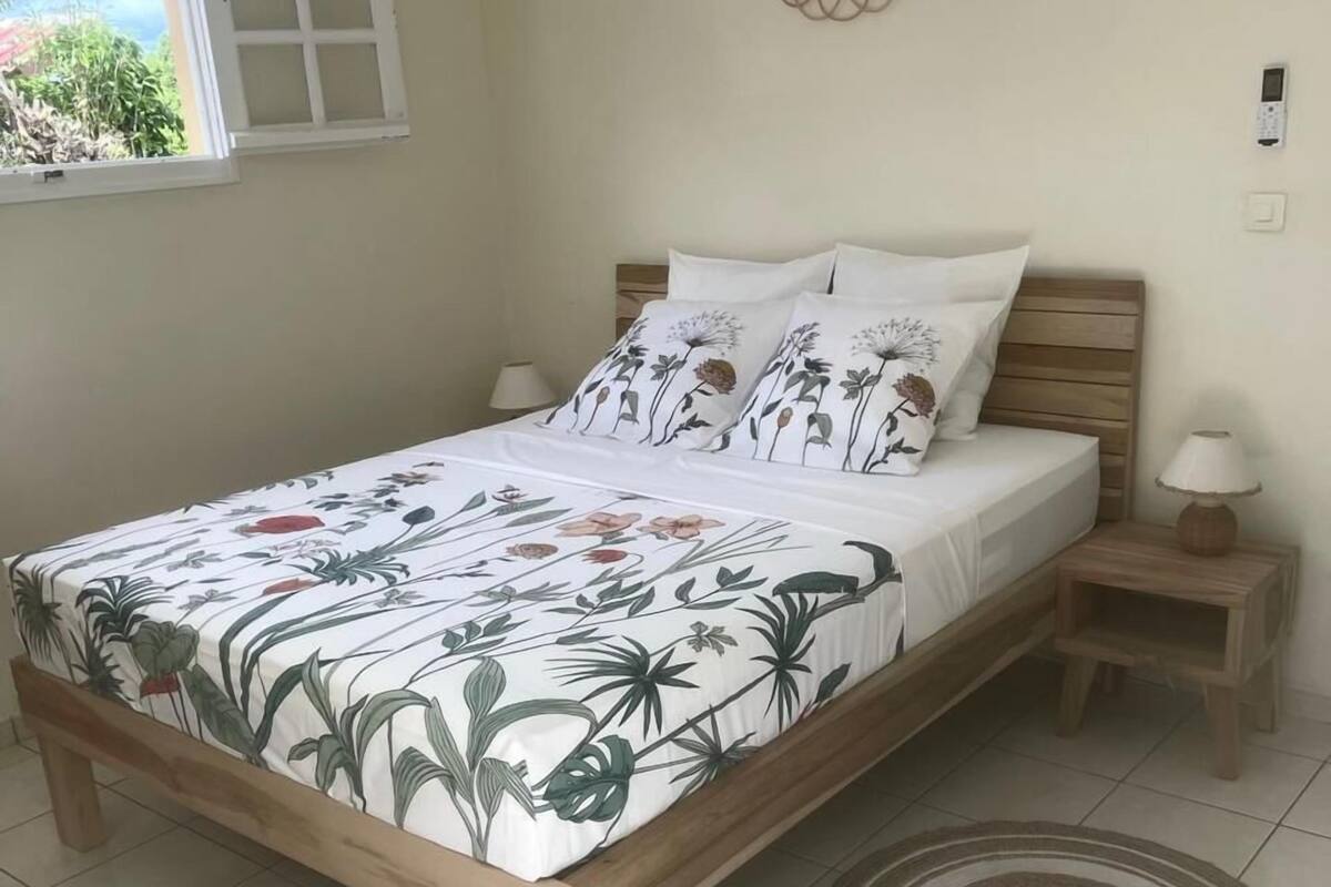 A bedroom with a bed, nightstands, a mirror, and a window.