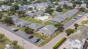 Un quartier résidentiel composé de maisons individuelles, d’une piscine et d’un parking.