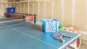 Una mesa de ping pong con una paleta azul para tenis de mesa y una pelota de tenis de mesa.