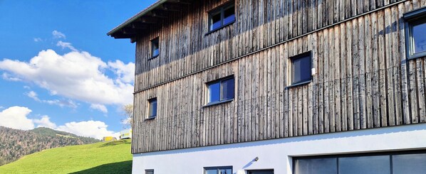 Un edificio de varios pisos con fachada de madera y numerosas ventanas.