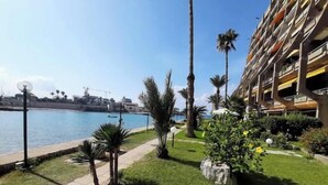 A hotel with a poolside area, palm trees, and a view of the sea. - Big Seaview studio, 24h electricity, beach + pool (Jabal Lubnan)