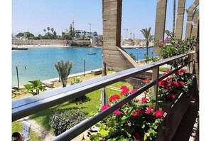 Ein Balkon mit Blick auf einen Strand und das Meer.