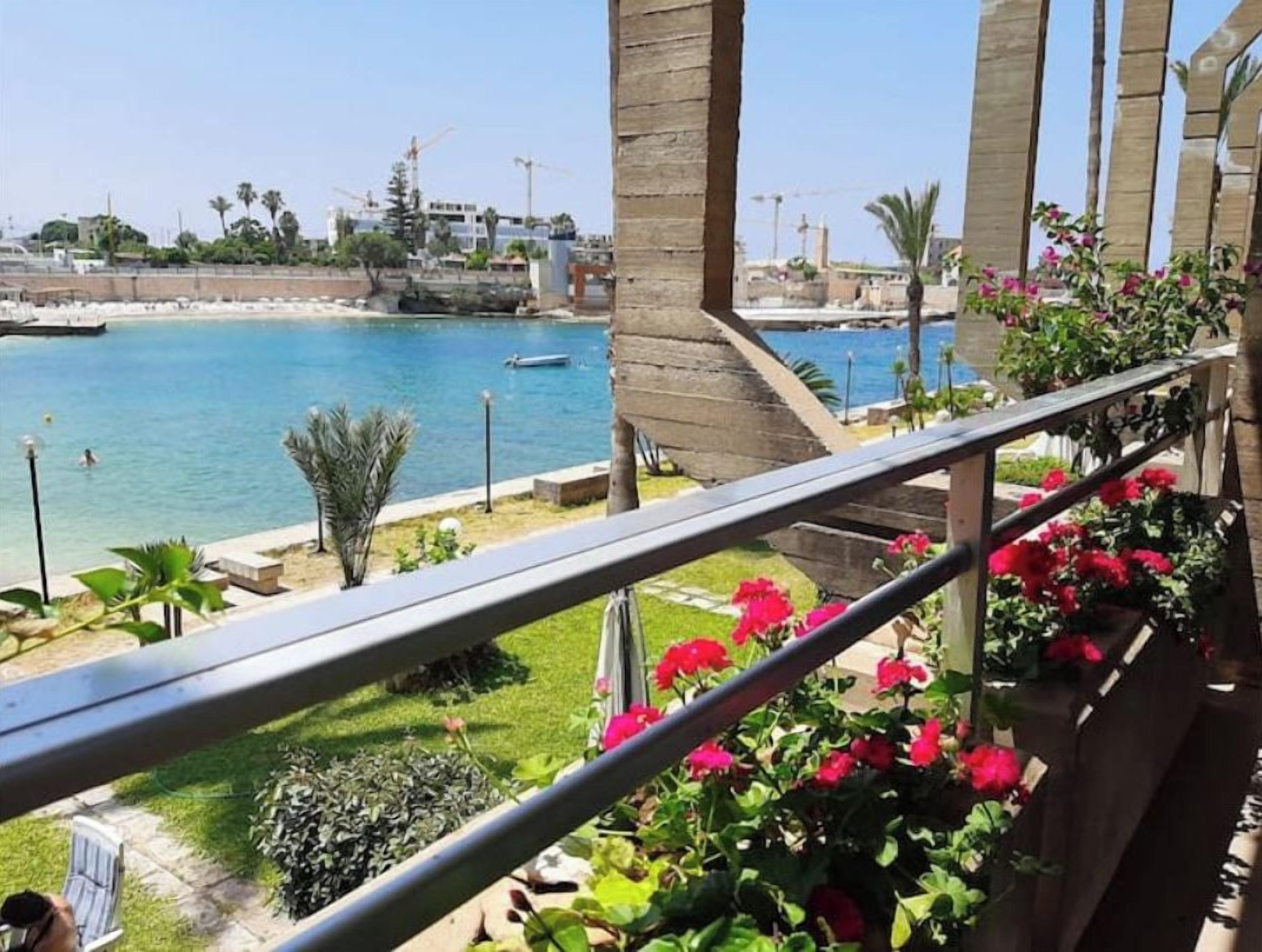 Un balcon avec vue sur une plage et la mer.