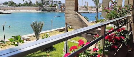 Un balcon avec vue sur une plage et la mer.