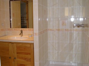 Ein Badezimmer mit Waschbecken, Spiegel und Dusche.