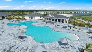 Un resort con un amplio espacio de piscina, numerosas tumbonas y un pabellón cubierto.