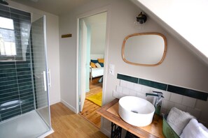 A bathroom with a glass shower enclosure, a white sink, and a mirror on the wall. - Les Suites Fisel (Rostrenen)
