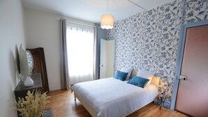 A bedroom with a bed, bedside table, and a mirror. - Les Suites Fisel (Rostrenen)