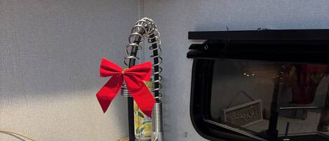Un lavamanos de cocina con grifo de acero inoxidable, un lazo rojo y un letrero de madera con la palabra