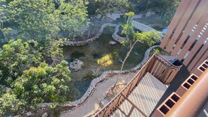 A view of a courtyard with trees, a stone pathway, and a bridge. - Unique Rooftop Sea View Walking to Beach The Best (Tulum)