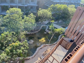 Vista de un patio con árboles, un sendero de piedra y un puente.