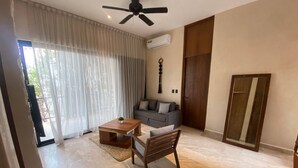 A spacious living area with a ceiling fan, a sofa, a coffee table, and a dining table with chairs. - ¡PH 3 Quarts Terrace and Private Pool AZ Premium! (Tulum)