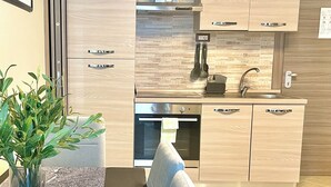 A modern kitchen with wooden cabinets, a stainless steel range, and a built-in oven. - InCity Suite: Elegant Downtown Business and Urban Living in the Heart of the City (Salerno)