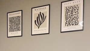 A wall with three framed artworks, a coffee machine, and a tray with cups and a box. - InCity Suite: Elegant Downtown Business and Urban Living in the Heart of the City (Salerno)