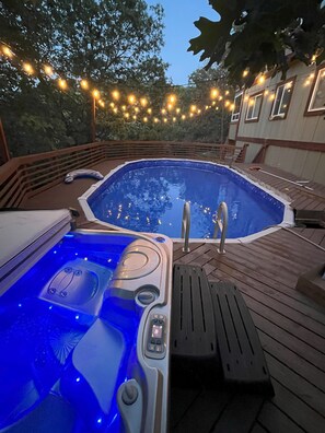 A hot tub with blue LED lights, a wooden deck, and string lights in the background. - 3-bedroom cabin in lovely Lake Arrowhead with AC, fitness room (Lake Arrowhead)