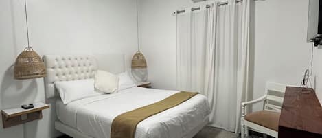A modern bedroom with a large bed, a bedside table, a hanging lamp, a chair, and an air conditioning unit.
