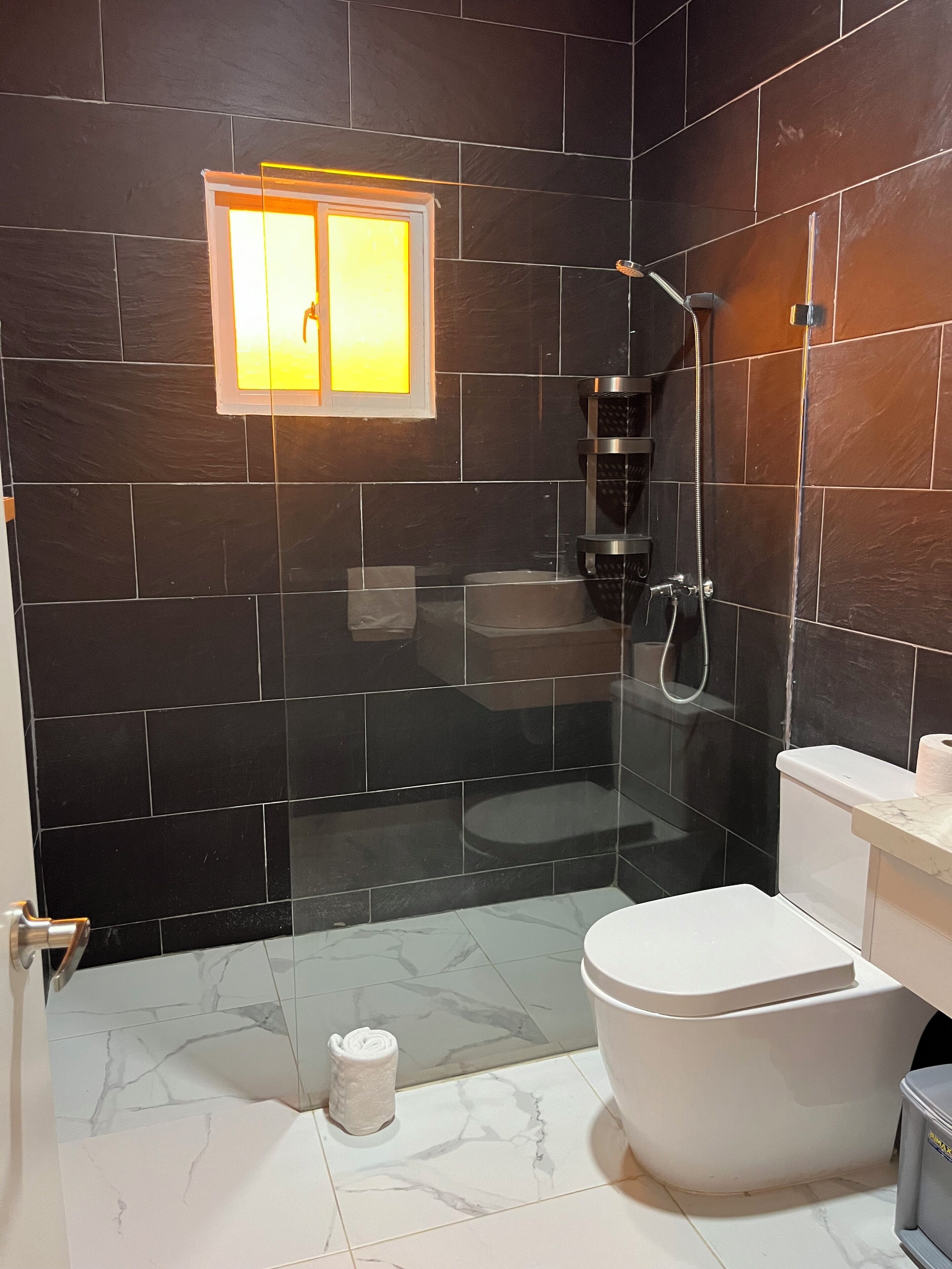 A bathroom with a shower, toilet, and sink.