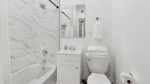 Un baño moderno con bañera, inodoro y lavamanos.