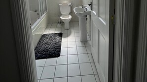 Une salle de bain avec des toilettes, un lavabo et une douche.