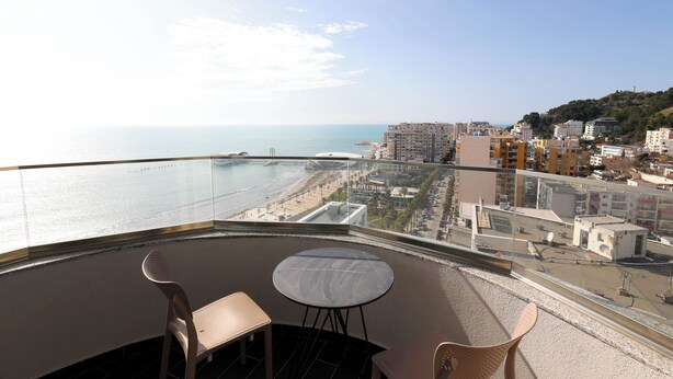 A balcony with a view of the sea, a beach, and buildings. - Superb apartment with Seaview (Durrës)