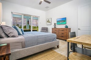 A bedroom with a bed, a desk, a chair, a dresser, and a TV. - Duck Key Bimini Retreat 3 bedroom 2 bath home with swim spa (Duck Key)