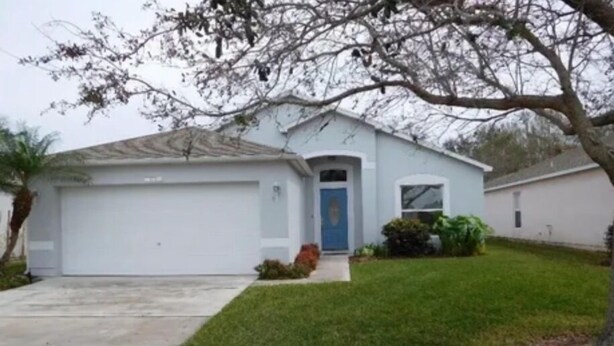 A single-story house with a garage, a front door, and a small front yard.