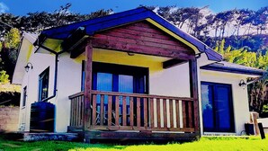 Una casita de un piso con porche y garaje.