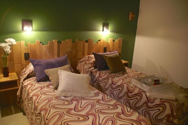 Un dormitorio con cabecera de madera, ropa de cama estampada y lámparas de noche.