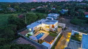 Una casa moderna con piscina, ventanas amplias y un jardín bien cuidado.