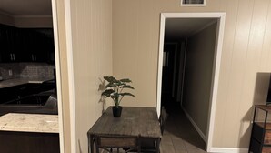 A kitchen with a dining table and chairs, a potted plant, and a TV on a stand.