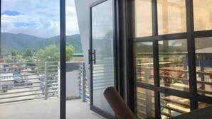 A balcony with a view of mountains and a parking area. - Hotel Rupert A -Deluxe Suite King Bedroom (Aurora)
