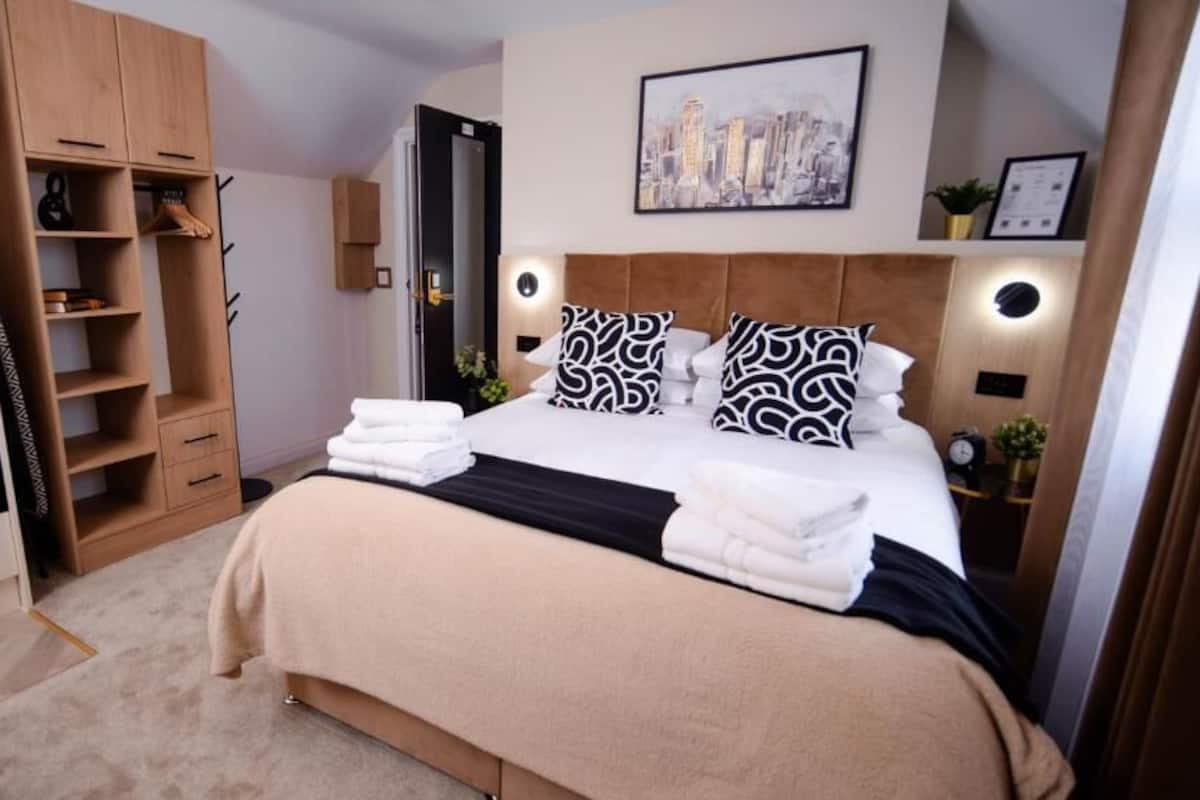 Una habitación de hotel con cama, armario, escritorio y televisión.