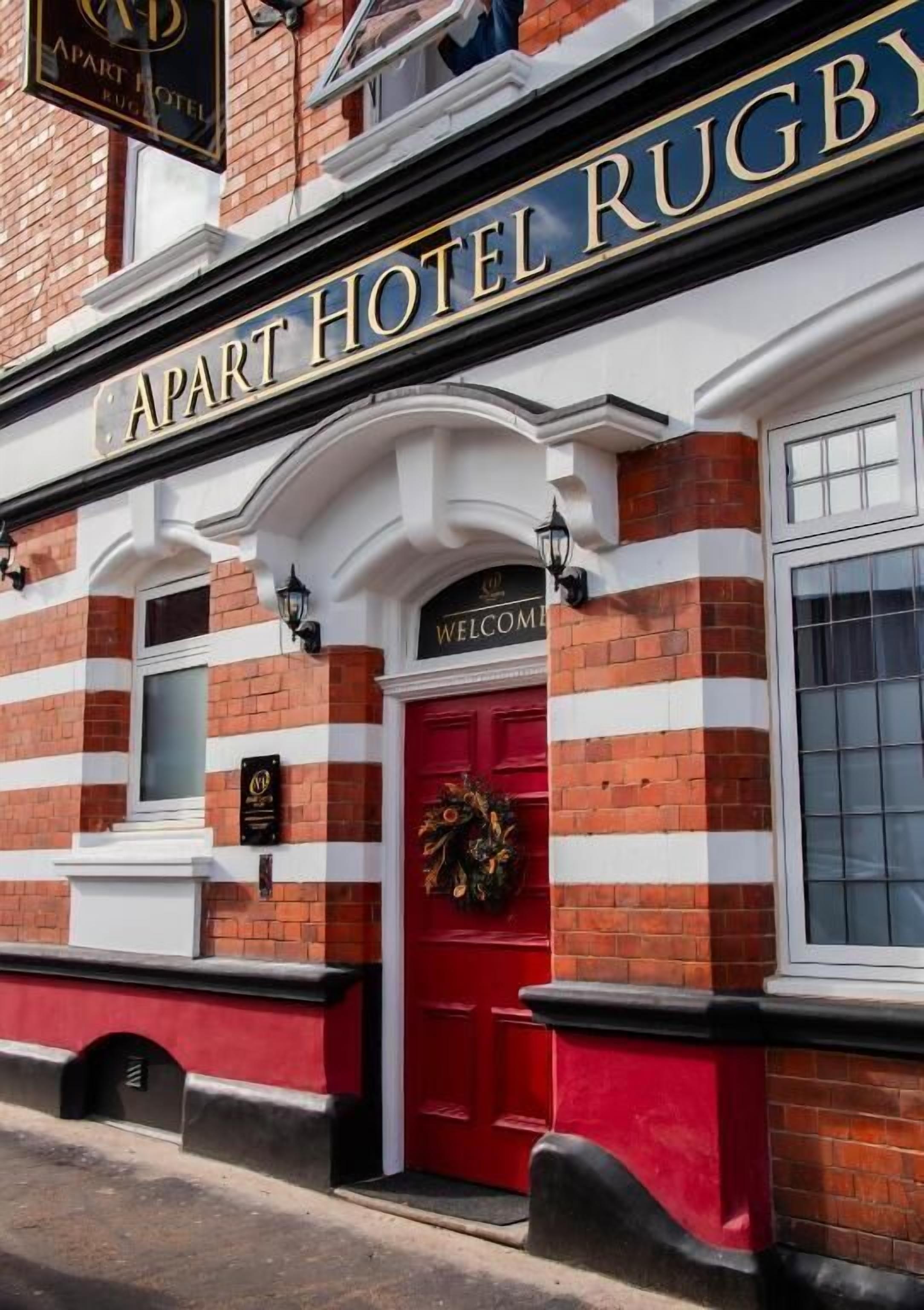 A hotel with a red door and a sign that reads "APART HOTEL RUGBY."