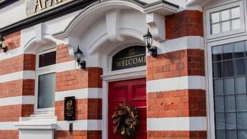 A hotel with a red door and a sign that reads "APART HOTEL RUGBY."