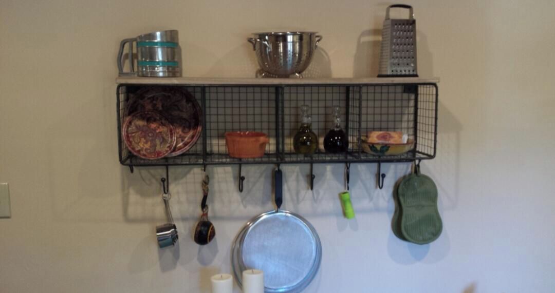 Una cocina con un tendedero que sostiene diversos utensilios y utensilios de cocina.