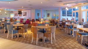 A spacious indoor area with multiple tables and chairs, some with patterned upholstery. - Lodge - Sleeps 4, Near Beach & Free Parking (New Quay)