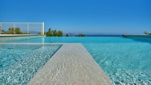 A clear blue infinity pool with a view of the ocean and distant mountains. - Villa Kallisti - Sea View & Private Pool (Corfu)