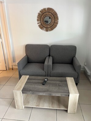 A grey sofa with a wooden coffee table in front. - Résidence hôtelière Le Manguier Panoramique (Trois-Ilets)