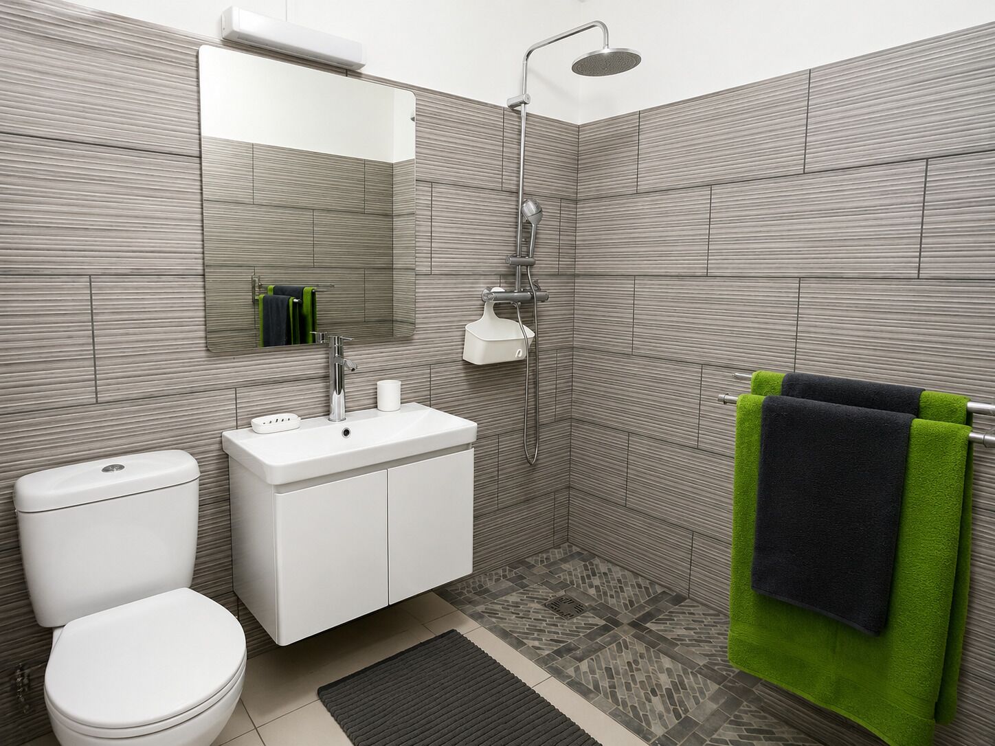 Une salle de bain moderne équipée de toilettes, d’un lavabo et d’une douche.