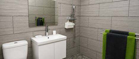 Een moderne badkamer met toilet, wastafel en douche.