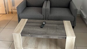 A grey sofa with a wooden coffee table in front.
